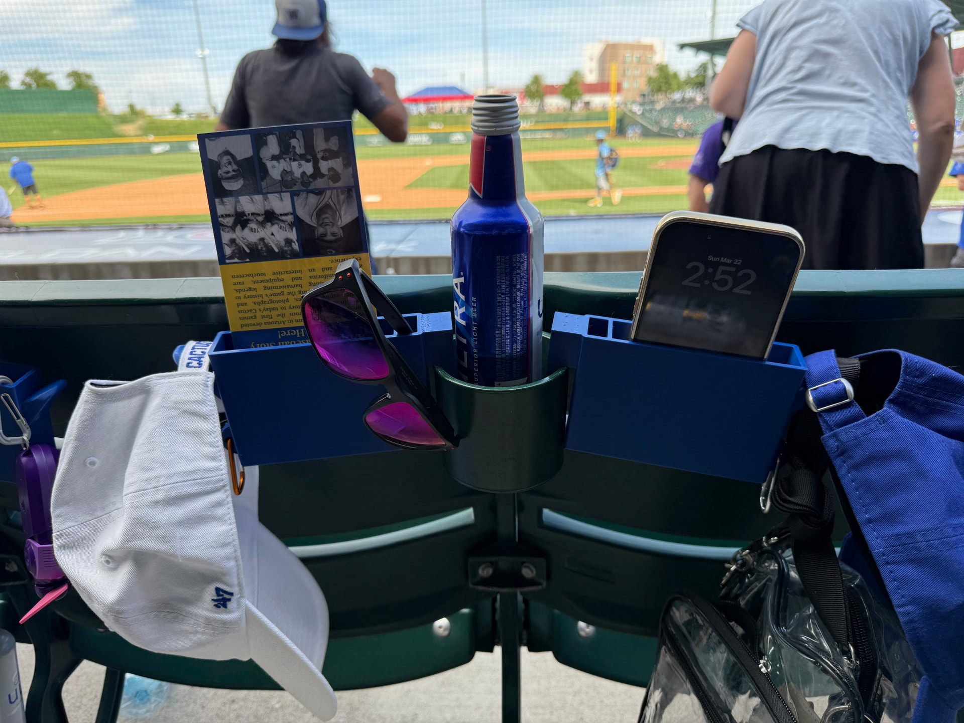 A pair of SNAC-KLIPs mounted on stadium seat cup holders at a ballpark